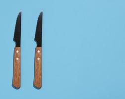 Knife with a wooden handle on a blue background, top view photo