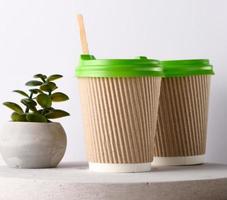 Paper brown cups with a plastic green lid for coffee and tea photo