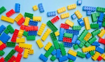 Multi-colored plastic cubes of a children's designer on a blue background, top view photo