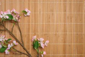 A branch with textile cherry blossoms on a brown background, top view, photo