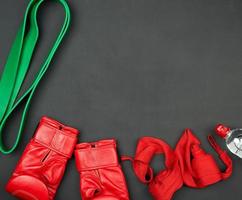 a pair of red leather boxing gloves, a textile bandage for bandaging the athletes hands, bottle of water photo