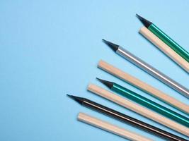 Wooden pencils on a blue background, top view photo