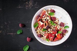 Chia seed pudding made with raspberries,  figs and mint on dark background.  The concept of good nutrition. Top view photo