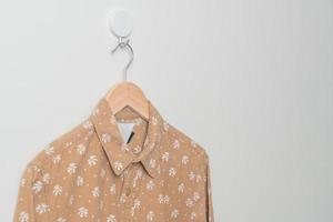 camisa colgante con colgador de madera en la pared foto