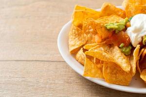 nachos tortilla chips with jalapeno, guacamole, tomatoes salsa and dip photo