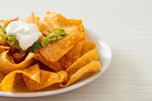 nachos tortilla chips with jalapeno, guacamole, tomatoes salsa and dip photo