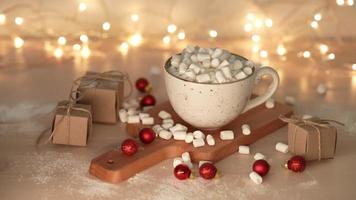 Marshmallows fallen lassen Tasse mit köstlich heiß Schokolade Kakao trinken. Beleuchtung sind auf im das Hintergrund. schleppend Bewegung video