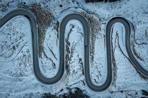 A snake shaped pass road in winter photographed from above photo