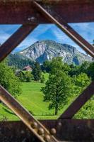 A swiss mountain landscape seen through a steel frame of a bridge photo