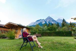 Young woman is standing by wooden houses. village in mountains. Travel, Lifestyle Concept. Alps, Europe. photo