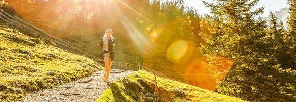 young fitness woman open arms on mountain peak photo