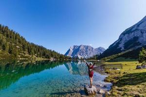 woman enjoying beauty of nature looking at mountain. Adventure travel, Europe. Woman stands on background with Alps. photo