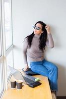 Beautiful businesswoman working on a laptop. Female freelancer connecting to internet via computer. Blogger or journalist writing new article. photo
