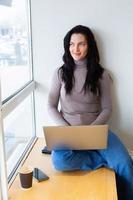 Beautiful businesswoman working on a laptop. Female freelancer connecting to internet via computer. Blogger or journalist writing new article. photo