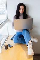 Beautiful businesswoman working on a laptop. Female freelancer connecting to internet via computer. Blogger or journalist writing new article. photo