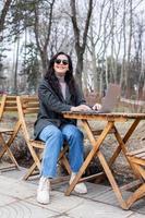 hermosa mujer de negocios trabajando en un ordenador portátil. hembra persona de libre dedicación conectando a Internet vía computadora. blogger o periodista escritura nuevo artículo. foto