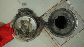 Drain cleaning. Clogged and dirty sewer pipes floor drain. Full of hair and accumulated clogged grease. Maintenance the floor drain sewage system in bathroom. fixing clean wash and unclog a drain. photo