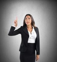 Businesswoman indicating and pointing up photo