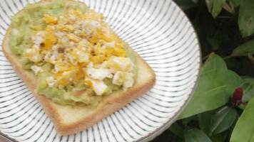 prato de torradas de abacate com ovo mexido frito. prato de refeição saudável video