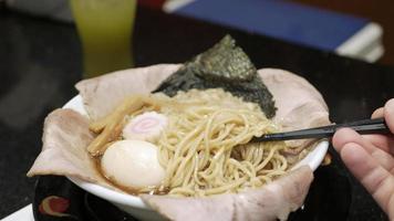 mit Essstäbchen wählen Ramen japanisch Nudel von Schüssel. japanisch Fast Food Ramen mit Schweinefleisch Scheibe video