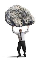 Stress concept with businessman holding a huge rock photo
