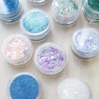 colorful painted multicolored glitter in clear jars in different angles. close-up photo