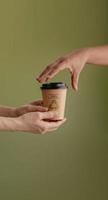 Recycled Packaging Concept. Barista Giving a Hot Cup of Coffee to customer. Zero Waste Materials. Environment Care, Reuse, Renewable for Sustainable Lifestyle. Vertical image photo