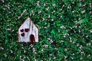 vivir en un concepto de estilo de vida de armonía. modelo de casa de madera sobre hierba verde. Cerca de la naturaleza foto