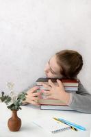 love of reading, little girl sitting at the table hugging a stack of books, book day photo