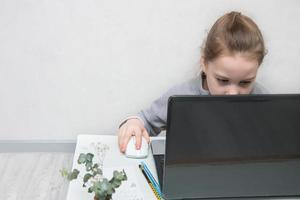 little one is doing tasks in a laptop with concentration, back to school photo