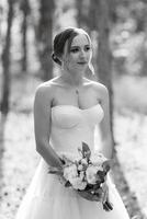 joven novia en un blanco corto vestir en un primavera pino bosque foto