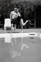 chico y un niña en baños trajes son relajante, cerca el azul piscina foto