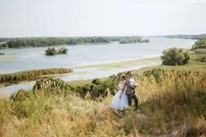 young couple a guy and a girl are walking in the green hills photo