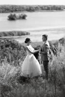 young couple a guy and a girl are walking in the green hills photo