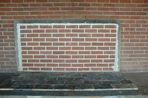 old fireplace covered with red bricks or masonry photo