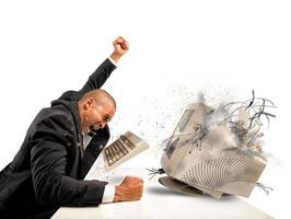 Angry businessman breaking a computer photo