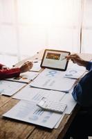 Group of confident business people point to graphs and charts to analyze market data, balance sheet, account, net profit to plan new sales strategies to increase production capacity. photo