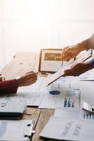 Group of confident business people point to graphs and charts to analyze market data, balance sheet, account, net profit to plan new sales strategies to increase production capacity. photo