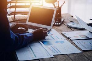 Group of confident business people point to graphs and charts to analyze market data, balance sheet, account, net profit to plan new sales strategies to increase production capacity. photo