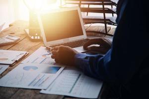 Group of confident business people point to graphs and charts to analyze market data, balance sheet, account, net profit to plan new sales strategies to increase production capacity. photo