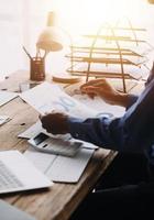 Group of confident business people point to graphs and charts to analyze market data, balance sheet, account, net profit to plan new sales strategies to increase production capacity. photo