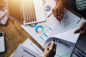 Group of confident business people point to graphs and charts to analyze market data, balance sheet, account, net profit to plan new sales strategies to increase production capacity. photo