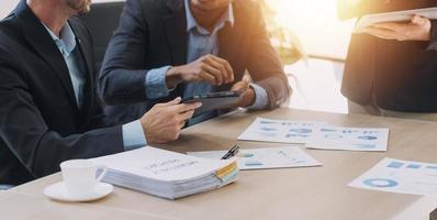 Financial analysts analyze business financial reports on a digital tablet planning investment project during a discussion at a meeting of corporate showing the results of their successful teamwork. photo