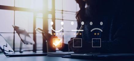 servicio al cliente y concepto de satisfacción, gente de negocios tocando la pantalla virtual en el icono de la cara feliz para dar satisfacción en el servicio. calificación muy impresionado. foto