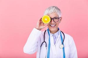 Dietician holding an orange. Smiling nutritionist holding a sliced orange, vitamins and healthy diet concept. Good medical healthcare nutrition concept. photo
