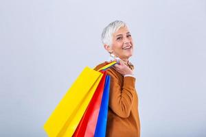 Mature attractive woman in enjoying a good shopping , with bags in hand. Senior happy summer shopping woman with shopping bags isolated on white background photo