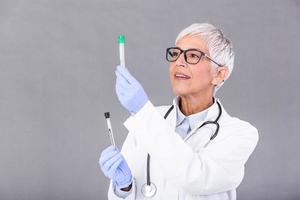 Female doctor or technician holding test tube Medical equipment. Blood or virus test. Senior doctor woman working with blood samples in test tubes, closeup photo