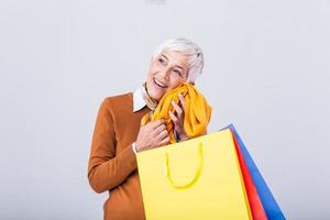 Happy mature good looking woman happy with her purchase, holding new cardigan against her face and smiling. Shopping concept photo