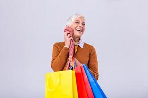 Happy mature good looking woman happy with her purchase, holding silk scarf against her face and smiling. Shopping concept photo