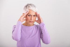 Attack of the monster migraine. Sinus pain. Unhappy Retired Senior Woman holding her head with pain expression . Face of senior woman suffering from headache photo